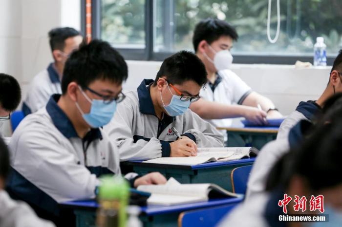 资料图：5月6日，武汉市第二中学高三学生戴着口罩上课。中新社记者 张畅 摄