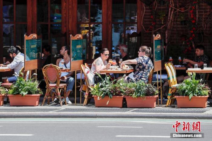 当地时间6月22日，纽约曼哈顿一家餐厅，顾客在户外用餐。当日，纽约市按预定计划进入第二阶段重启，市政府预计将有约30万人重返工作岗位。商场、影剧院、健身房等依然保持关闭。 中新社记者 廖攀 摄