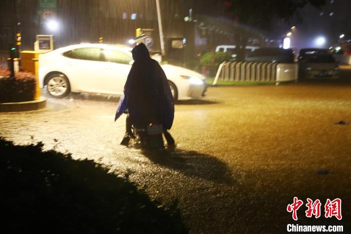 图为暴雨中的骑行者。　刘占昆 摄