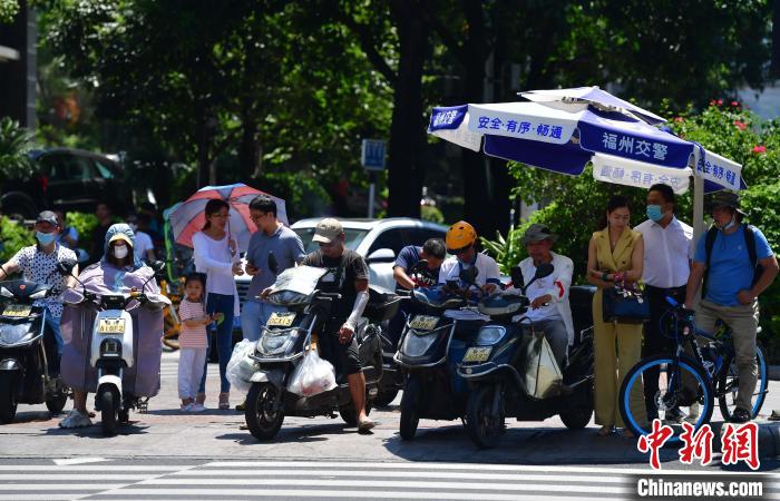 图为福州市民在烈日下出行。　张斌 摄