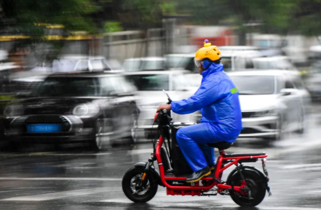  一名外卖员冒雨骑行送餐 许畅 摄